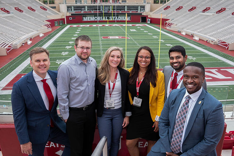 Six Kelley Direct students stand in front of the football field at Indiana University's Memorial Stadium. Networking opportunities with other students is one benefit offered by the online MS in Finance program.